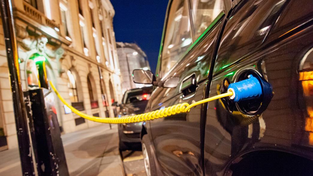 A close up of an electric car charging in the city