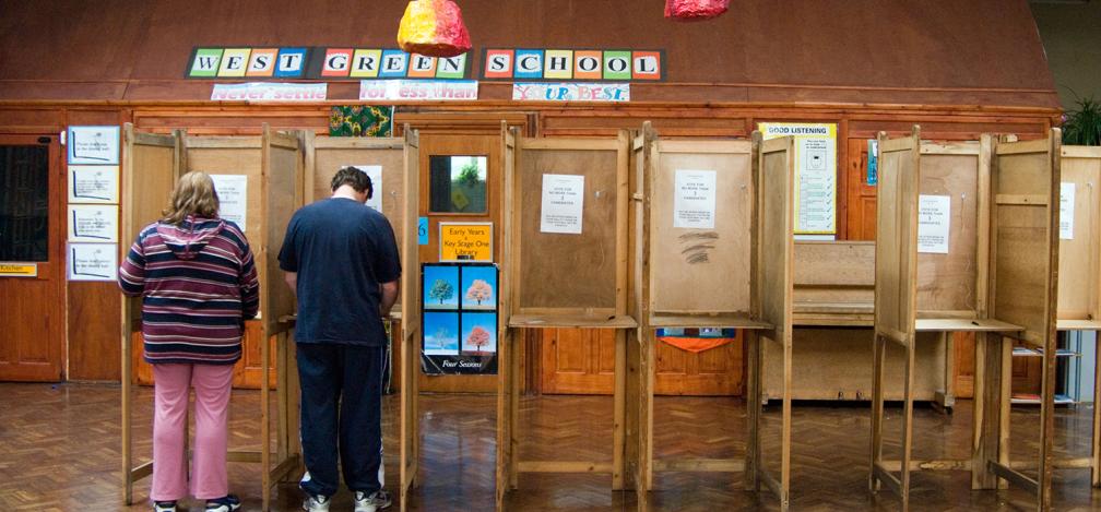 A man and a woman vote at a polling station in a school in Haringey.