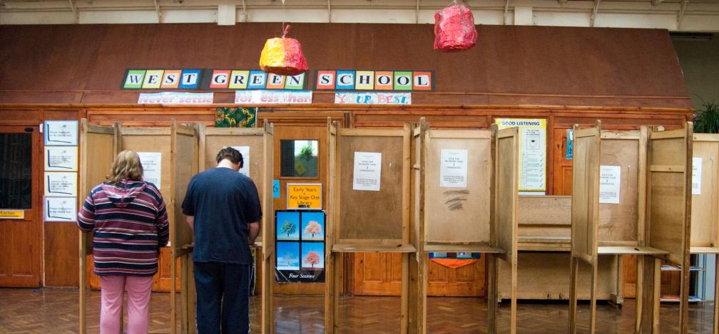 Two people voting inside a polling station in Haringey, London.