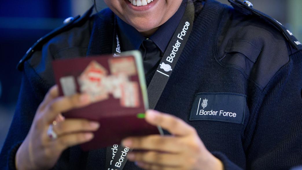 Border Force officer checking a passport