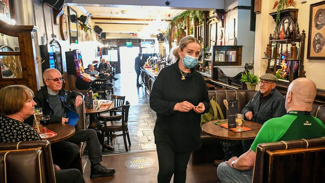 Bar staff in a pub wearing a face mask