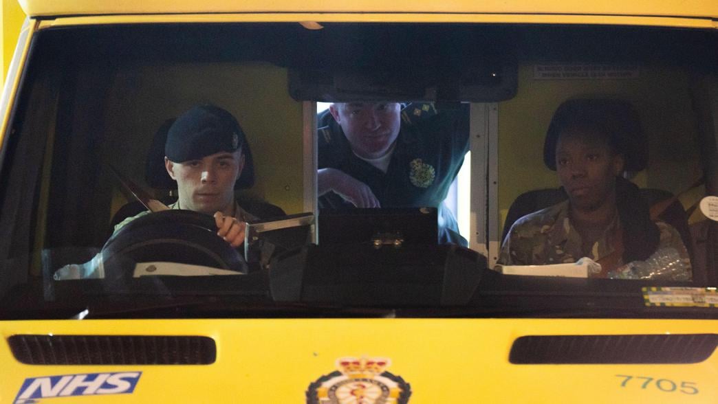 Armed forces personnel drive an ambulance out of St Mary's Hospital, north west London.