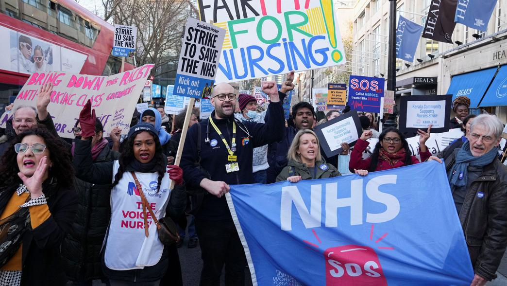 NHS nurses hold signs during a strike, amid a dispute with the government over pay, in London.