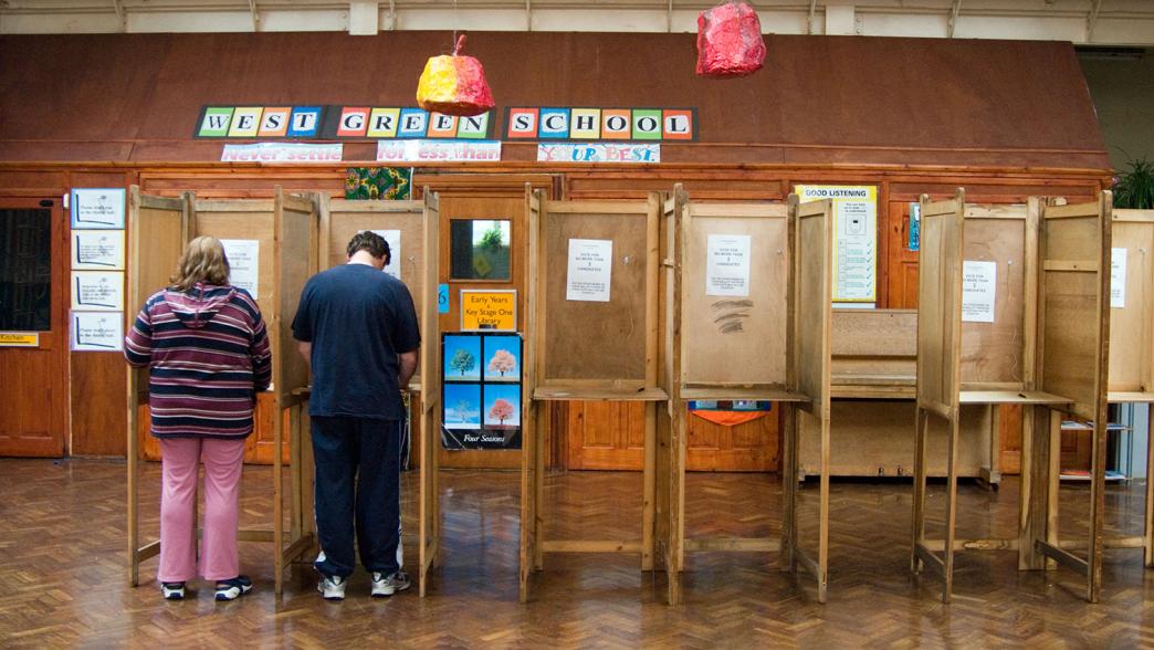 A man and a woman vote at a polling station in a school in Haringey.