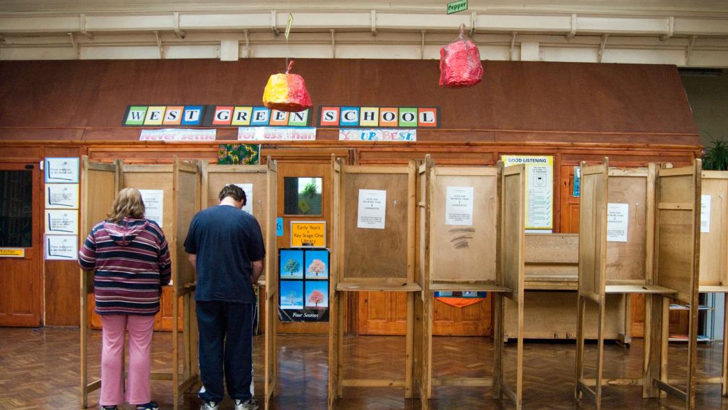 Two people voting inside a polling station in Haringey, London.
