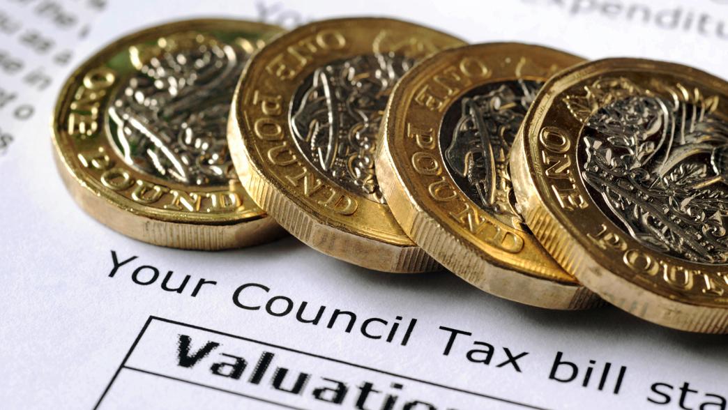 A council tax bill with four pound coins on top.
