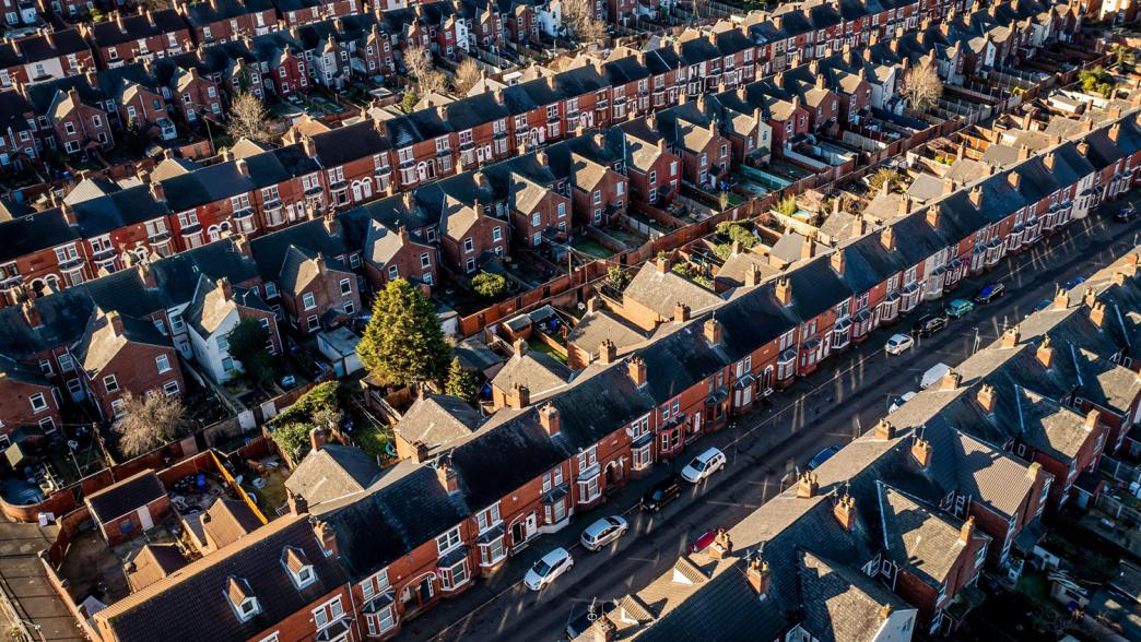 An aerial view of rows of back to back terraced houses in a working class area of a northern town in England.
