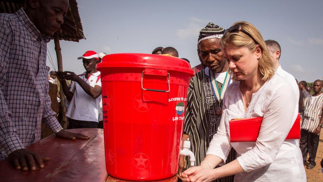 Justine Greening washing her hands as part of the Ebola virus decontamination process during a visit to Sierra Leone.