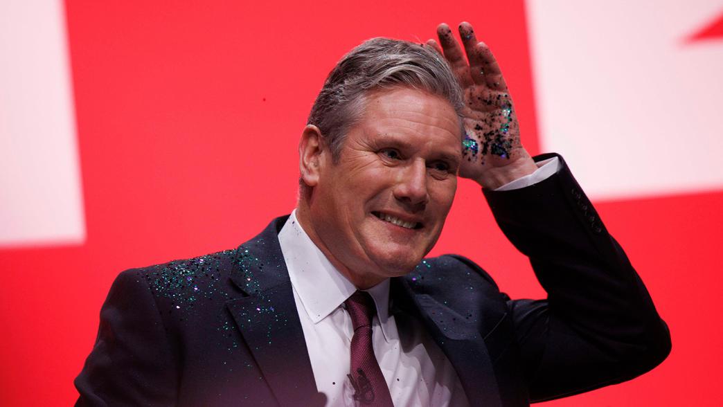 Sir Keir Starmer gives his keynote speech at the Labour Party Conference in Liverpool. In the photo, Starmer is brushing glitter out of his hair after a protestor jumped on stage a threw glitter on him.