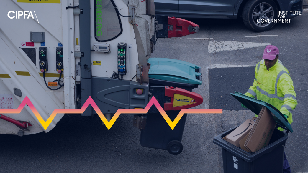 A waste disposal man loading bins onto a truck