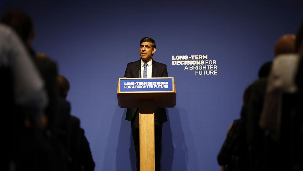 Prime minister Rishi Sunak delivers a speech on AI at Royal Society. He is stood at the lectern. Behind him are the Conservative Party's slogan: Long-term decisions for a brighter future