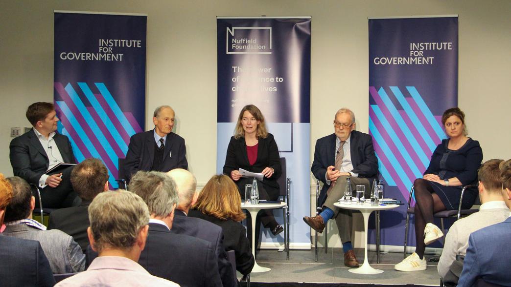 Conrad Smewing, Professor Hood, Gemma Tetlow, Sir Charles Bean, and Cath Haddon on stage at an Institute for Government event.