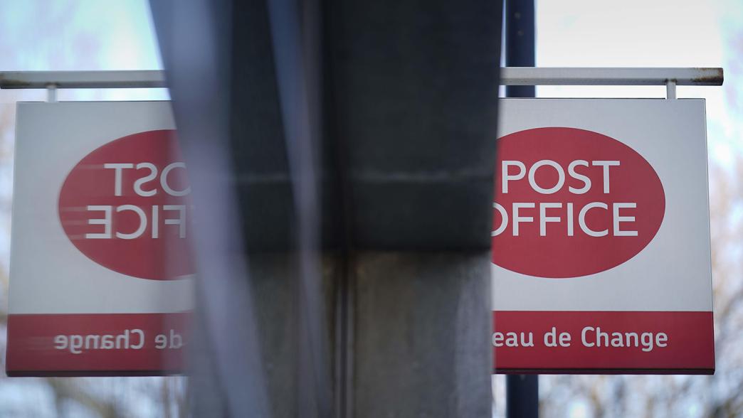 Post Office sign mirrored in a window