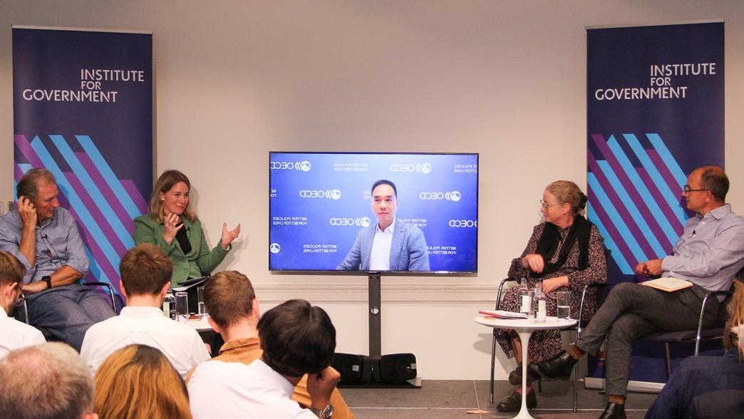 From left to right: Lord O'Donnell, Gemma Tetlow, Edwin Lau (appearing on screen), Anita Charlesworth and Chris Giles on stage at the IfG.