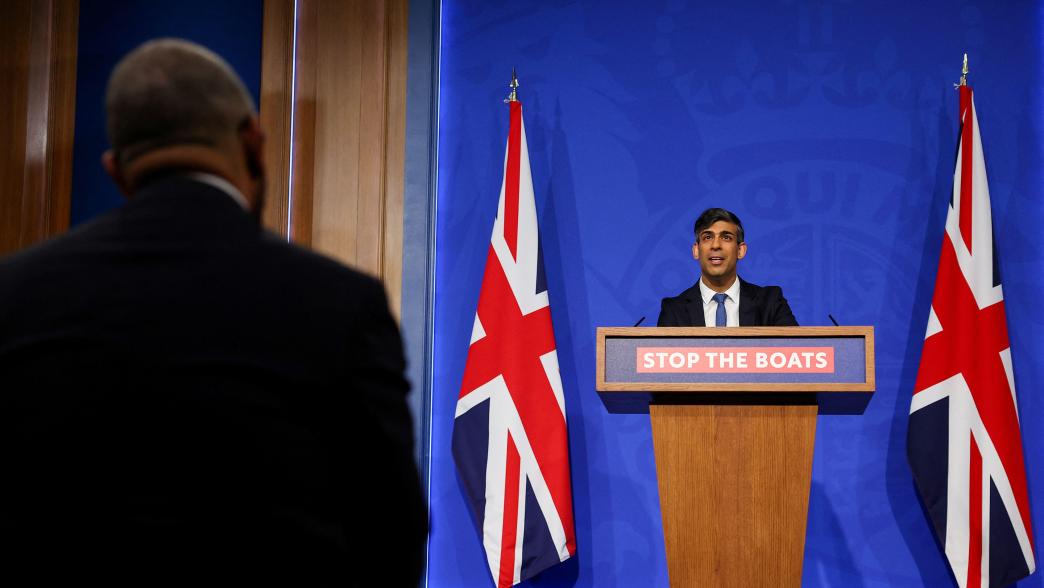 Prime minister Rishi Sunak speaks during a press conference in Downing Street, London. He is stood by a lectern which says 'Stop the Boats'.
