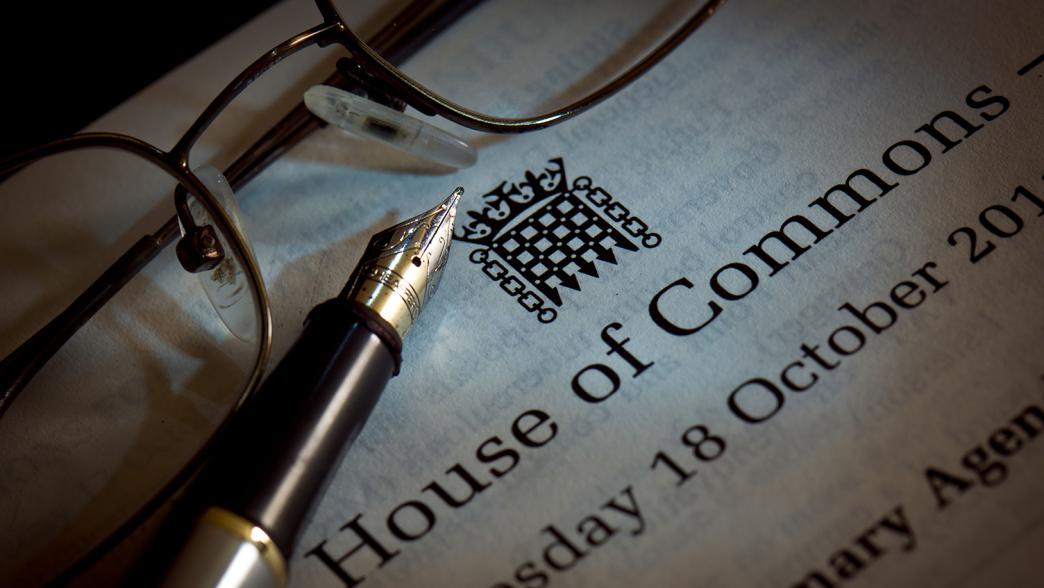 A House of Commons order paper with a pen and pair of glasses on top.