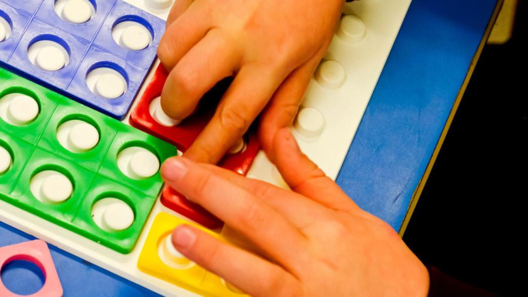 Close up of a child's hand playing with toys