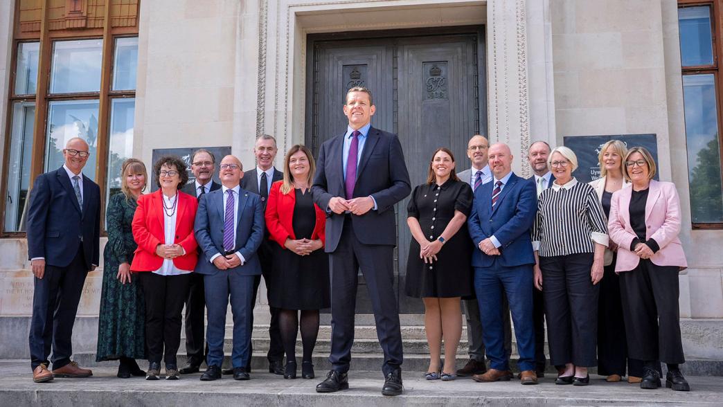 First Minister Rhun ap Iorwerth speaks on the steps of the Welsh Government building in Cardiff, supported by his new cabinet. 
