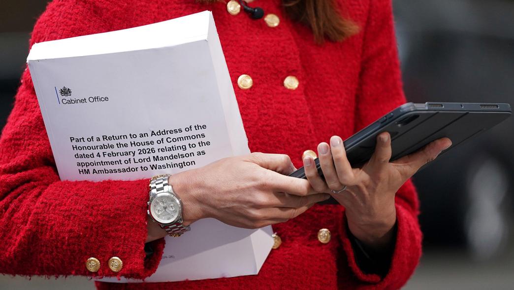 A journalist holds a copy of the Mandelson files.