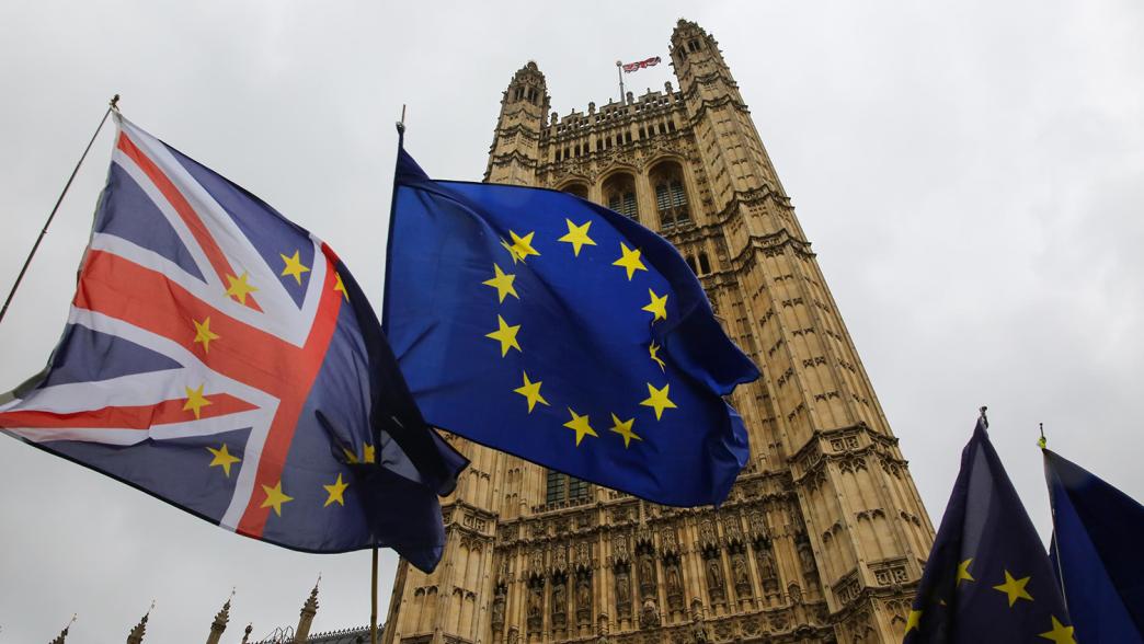 Union Jack and EU flags waving outside the Palace of Westminster