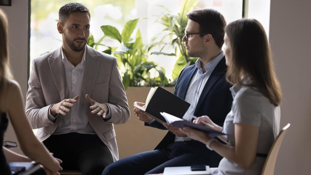 Group of businesspeople negotiating gathered in office