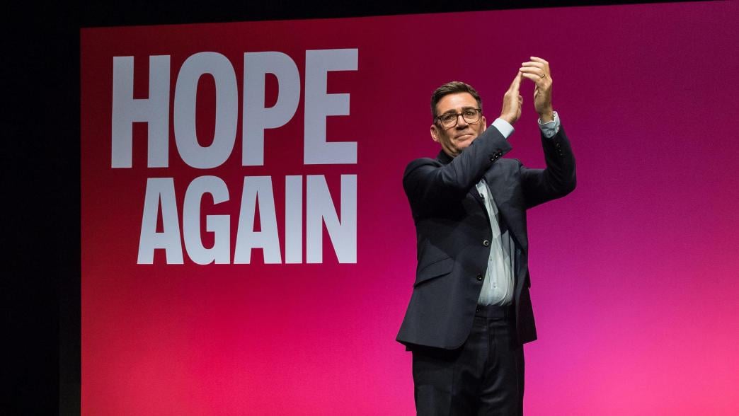 Andy Burnham on stage at the Labour Party Conference. Behind him the screen reads: Hope Again