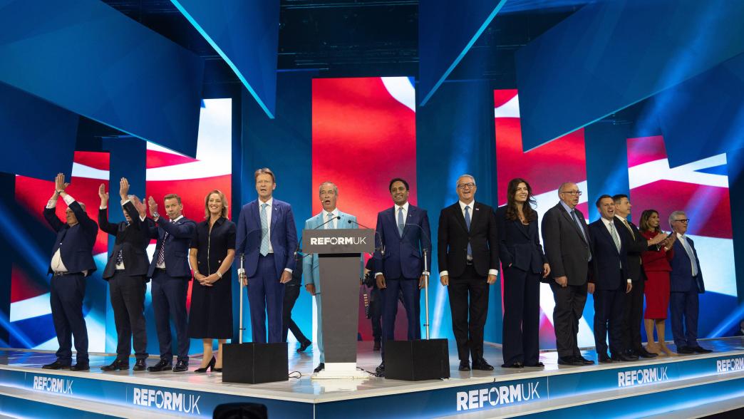 The Reform UK party on stage in Birmingham, singing the UK national anthem.