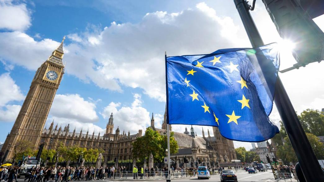 EU flags waving outside parliament.