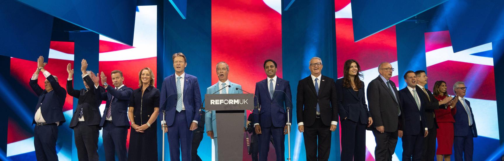The Reform UK party on stage in Birmingham, singing the UK national anthem.