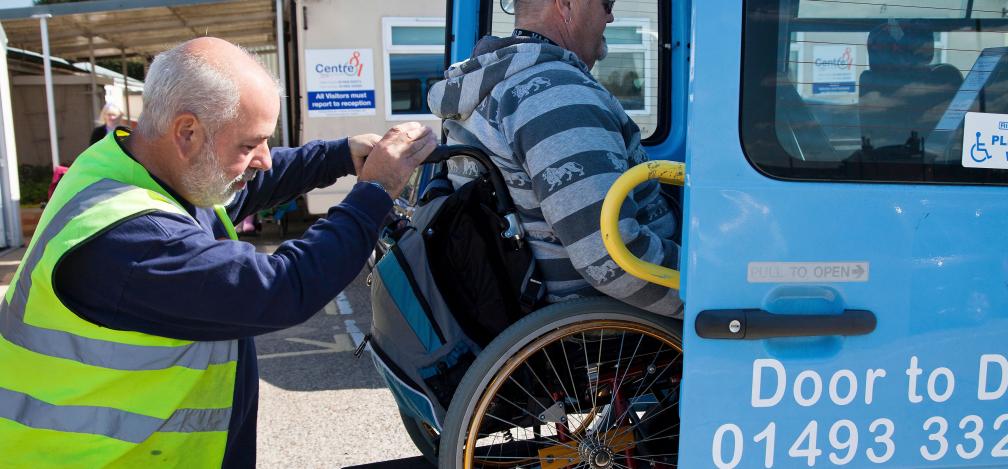 A wheelchair user being lifted into a van