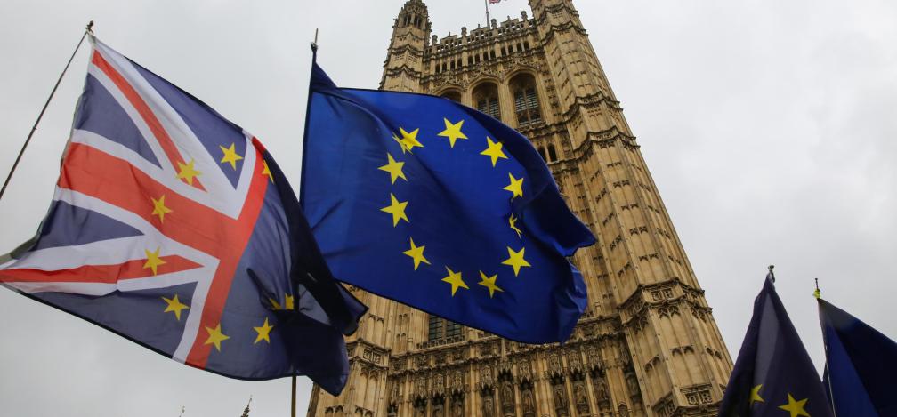 Union Jack and EU flags waving outside the Palace of Westminster