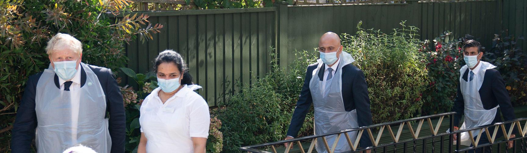 Boris Johnson, Sajid Javid and Rishi Sunak visit a care home. They are pictured wearing face masks and PPE. 