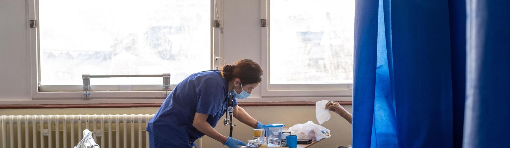 An NHS worker speaking to a patient on the ward