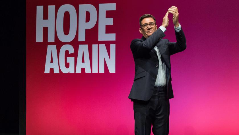 Andy Burnham on stage at the Labour Party Conference. Behind him the screen reads: Hope Again