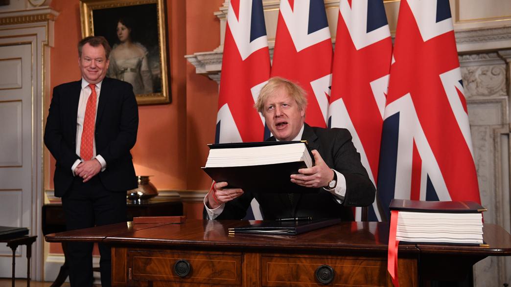 Boris Johnson holds the UK-EU Trade and Cooperation Agreement. On his right is Lord Frost, Brexit chief negotiator.