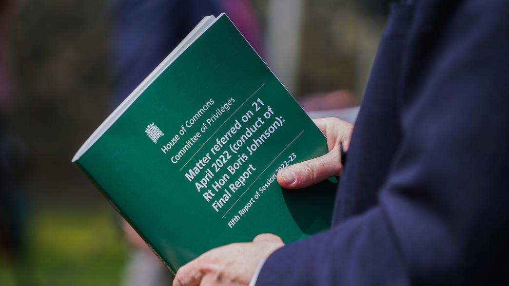 Jacob Rees Mogg holds the final report by the House of Commons privileges committee into the conduct of former Prime Minister Boris Johnson