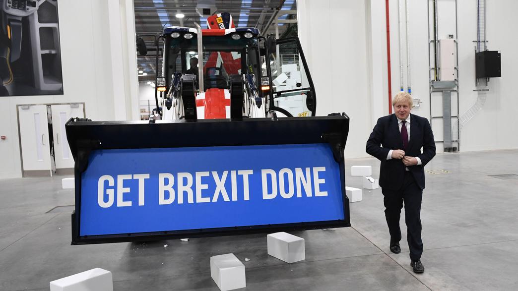 Boris Johnson standing next to a digger which says 'Get Brexit Done'